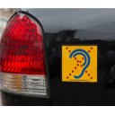Limited Hearing reflecterende waarschuwingssticker op achterzijde van auto met geel en blauw oor symbool Limited Hearing reflecterende waarschuwingssticker op achterzijde van auto met geel en blauw oor symbool