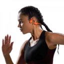 Vrouw in zwarte sportkleding draagt de Shokz OpenRun Pro 2 Mini hoofdtelefoon in oranje tijdens een intensieve hardloopsessie – HearPlanet Vrouw in zwarte sportkleding draagt de Shokz OpenRun Pro 2 Mini hoofdtelefoon in oranje tijdens een intensieve hardloopsessie – HearPlanet