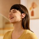 Vrouw geniet van muziek met de Shokz OpenFit Air roze hoofdtelefoon voor een comfortabele luisterervaring Vrouw geniet van muziek met de Shokz OpenFit Air roze hoofdtelefoon voor een comfortabele luisterervaring